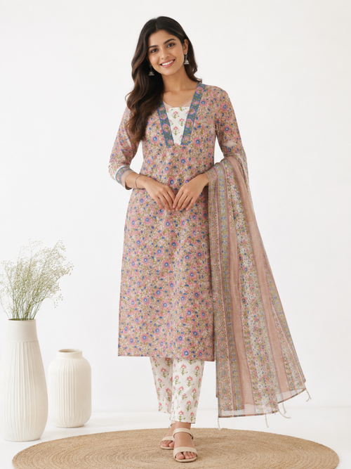 A woman models a traditional Indian salwar kameez suit set featuring a  kurta with a multicolor floral print, matching printed trousers, and a sheer dupatta